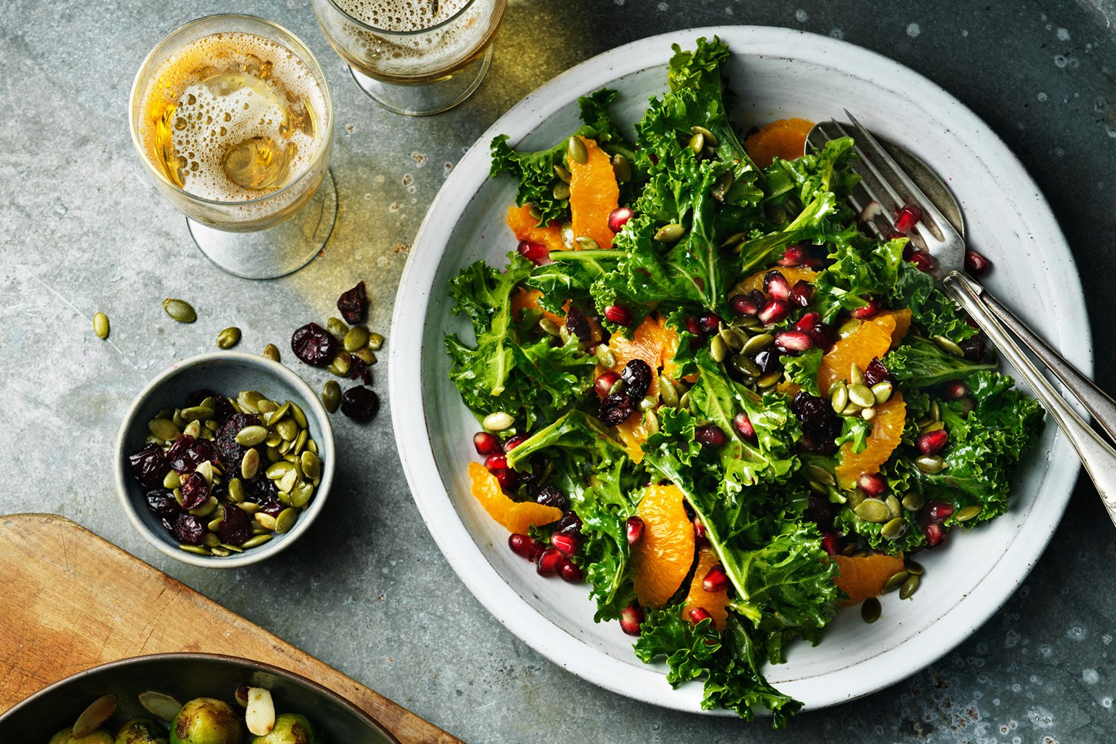 Salade van boerenkool met sinaasappel en granaatappel in een slakom