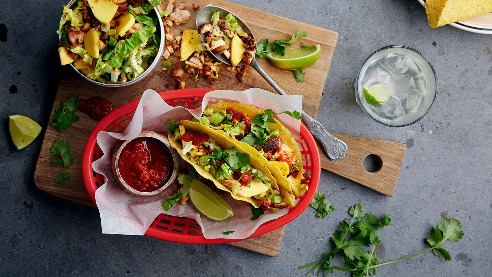 Twee taco's met kip geserveerd omp een rode plastic bord