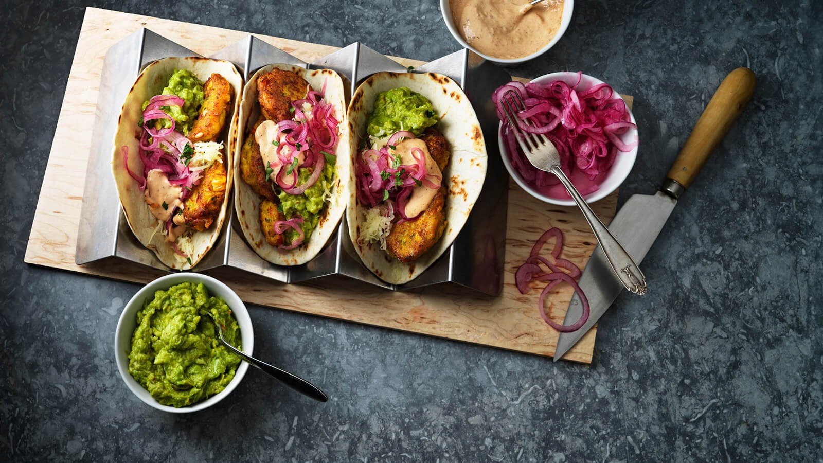 Tre tacos med cornfritters och guacamole