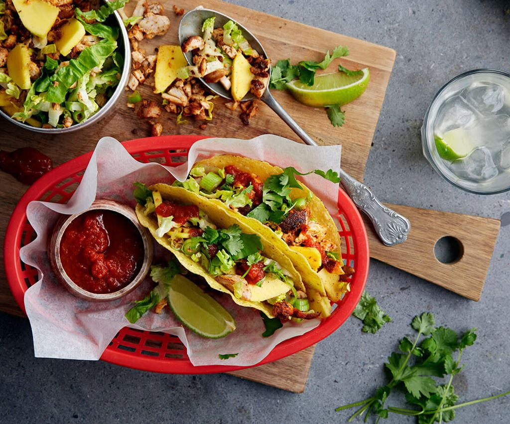 Twee taco's met kip geserveerd op een rode plastic bord