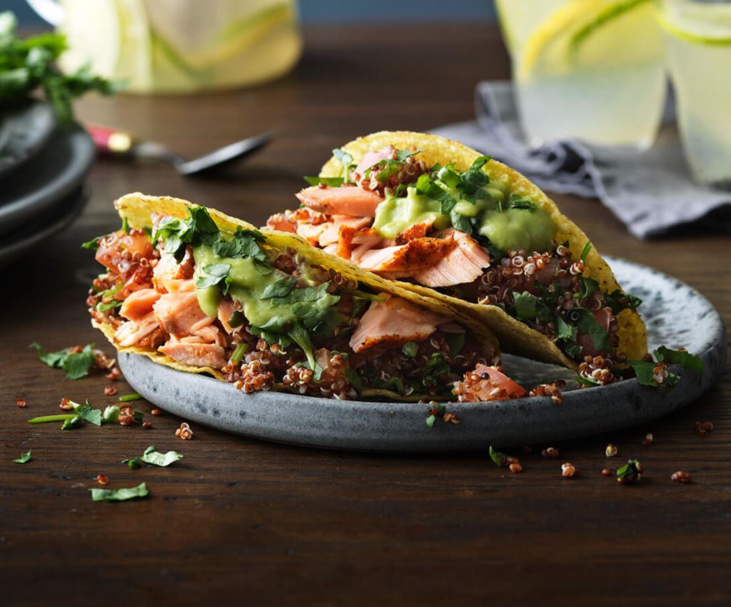 Two salmon tacos served on a plate