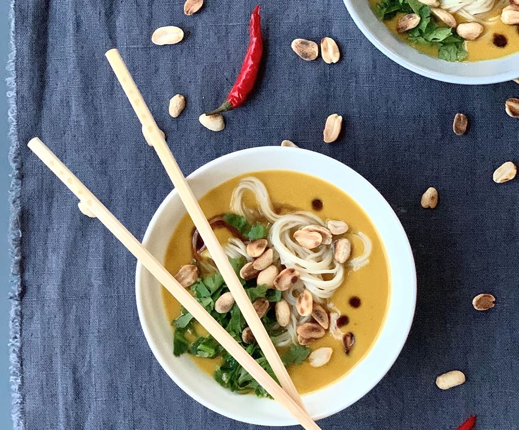 moliūgų sriuba su Ramen makaronais ir žalumynais dubenėlyje su aitriosiomis paprikomis