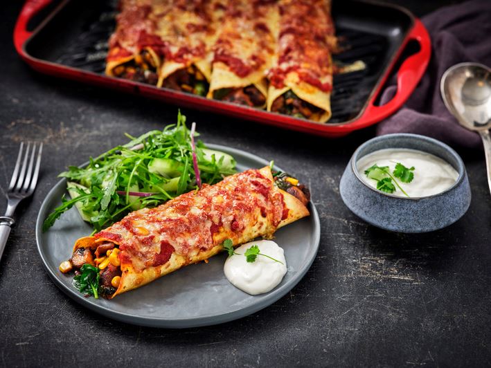 enchilada met spinazie en paddenstoelen op een bord